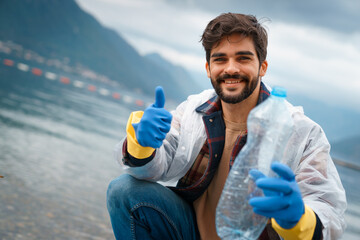 Cheerful content young man showing thumb up after successful cleaning all the recyclables from the...