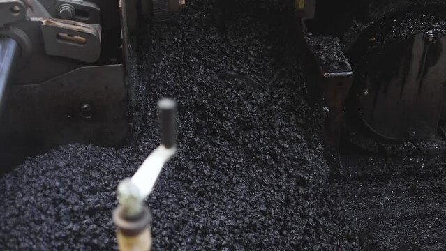 Process of asphalting, blacktopping and paving, asphalt paver machine and steam roller compactor during construction and repairing works, workers on the construction site, rental vehicle working
