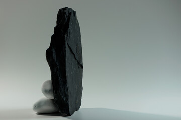 small white smooth stones behind one big black flat stone 