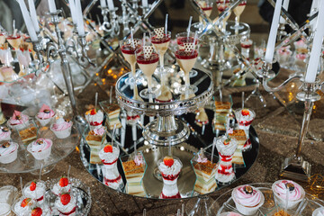 A sweet table at a wedding. Table with cakes and sweets at the festival. Birthday sweets
