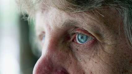 Macro close-up of a thoughtful senior man with blue eyes staring blank expression, pensive emotion...