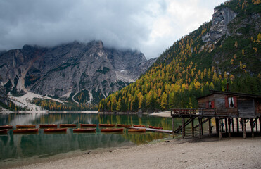 Wooden boats and Lago di Braies in Dolomites, and seekofel dolomite massif in Italy Europe