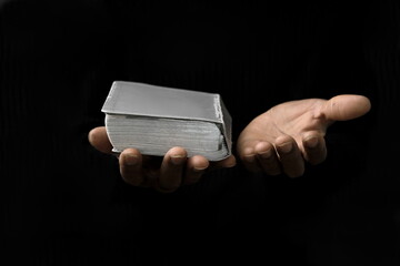 man praying to god with hands on bible together with black grey background stock image stock photo	