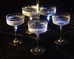 A glass of wine reflected in mirrors and illuminated by colored light