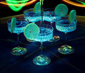 A glass of wine reflected in mirrors and illuminated by colored light