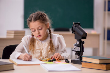 Fototapeta na wymiar Small girl studying in the classroom