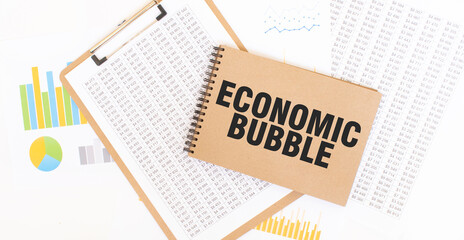 Text ECONOMIC BUBBLE on brown paper notepad on the table with diagram. Business concept