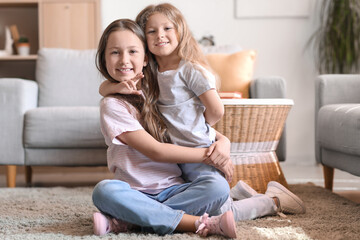 Cute little sisters hugging at home