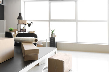 Interior of modern office with cardboard boxes on moving day