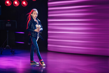 Girl child performs modern choreography with pointe shoes in her hands. Various directions in dance.