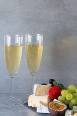 Assortment of cheese with fruits, grapes and white wine.