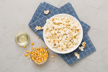 Prepared popcorn with ingredients on concrete background, top view
