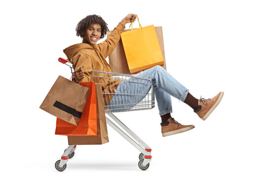 African american young man sitting inside a pushcart and holding shopping bags