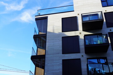 Look up to white appartment with balconies building towards blue sky. Kalamaja, Tallinn, Estonia