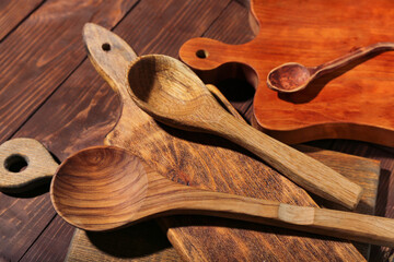 Different cutting boards and spoons on wooden background