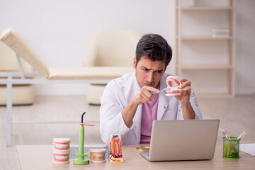 Young male dentist working in the clinic