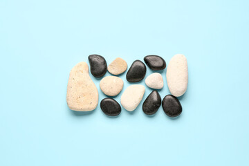 Obraz na płótnie Canvas Many pebble stones on blue background