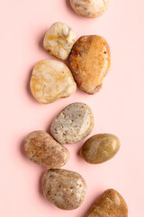 Fototapeta na wymiar Many pebble stones on pink background