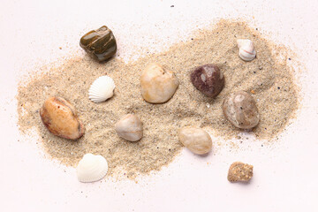 Fototapeta na wymiar Pebble stones, seashells and sand on white background