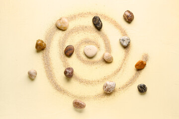 Fototapeta na wymiar Many pebble stones and sand on yellow background