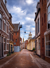 Fototapeta na wymiar Empty street of Groningen city, Netherlands, Europe. A paved red brick street.