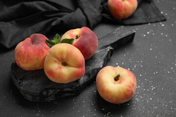 Board with sweet fig peaches and mint on black background