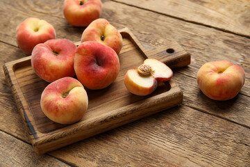 Board with sweet fig peaches on wooden background