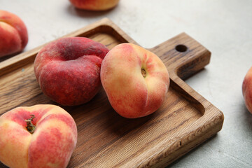 Wooden board with sweet fig peaches on grunge background