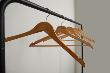 Rack with wooden clothes hangers on grey background - Powered by Adobe