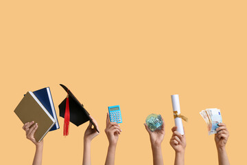 Female hands holding piggy bank, graduation cap, diploma and money on yellow background. Student loan concept