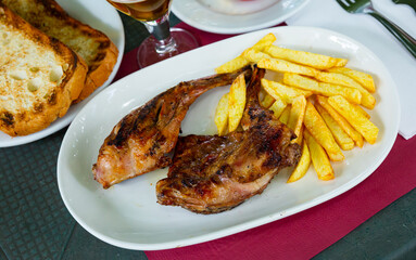 Plate with delicious fried rabbit and fries.