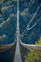 People while crossing the Tibetan bridge of Dossena.Which is the longest in the world