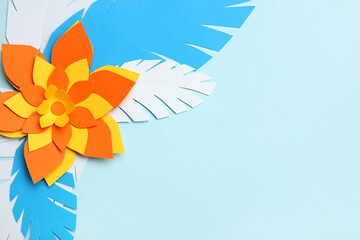 Colorful origami flower with leaves on light blue background