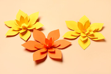 Colorful origami flowers on beige background