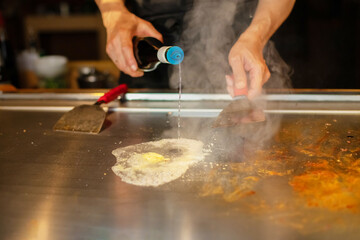 Chef cooking in Japanese teppanyaki restaurant