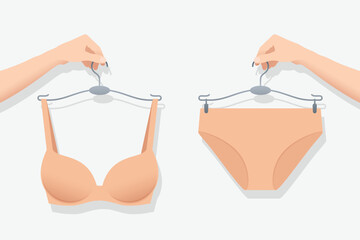 Panty and bra in flesh color on hangers in hands of woman