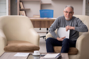 Old male employee working from home during pandemic