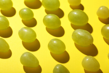 Sweet green grapes on yellow background