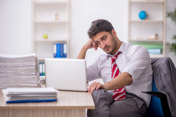 Young male employee and too much work in the office