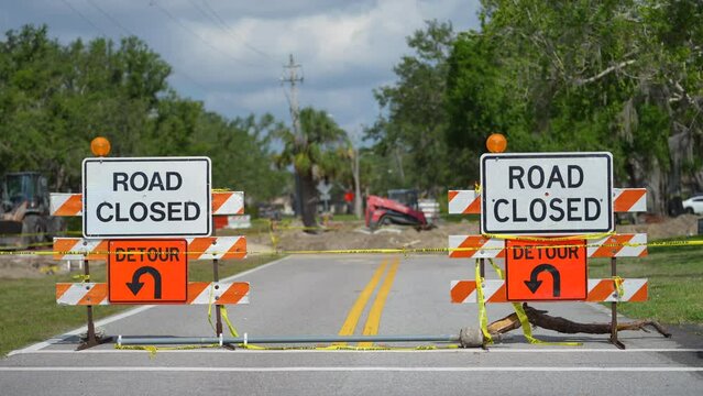 Yellow protective barrier at street construction site. Warning road sign about utility work
