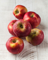 Ripe juicy red apples on a wooden white background. Harvesting.
