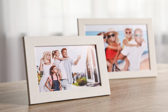 Pleasant memories. Frames with family photos on wooden table indoors, selective focus
