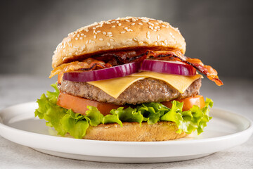 Delicious hamburger with meat, cheese, bacon and salad.