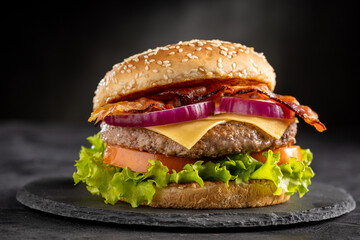 Delicious hamburger with meat, cheese, bacon and salad.