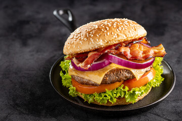 Delicious hamburger with meat, cheese, bacon and salad.