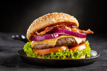 Delicious hamburger with meat, cheese, bacon and salad.