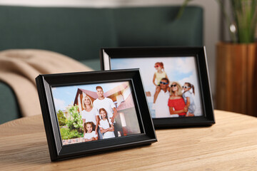 Frames with family photos on wooden table indoors
