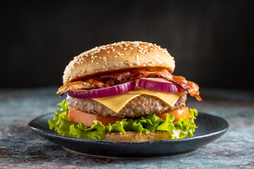 Delicious hamburger with meat, cheese, bacon and salad.