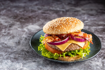Delicious hamburger with meat, cheese, bacon and salad.