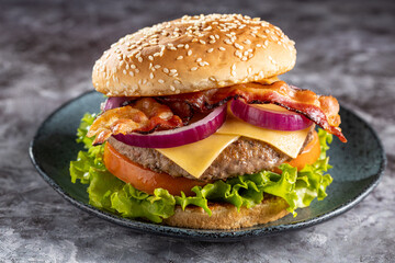 Delicious hamburger with meat, cheese, bacon and salad.